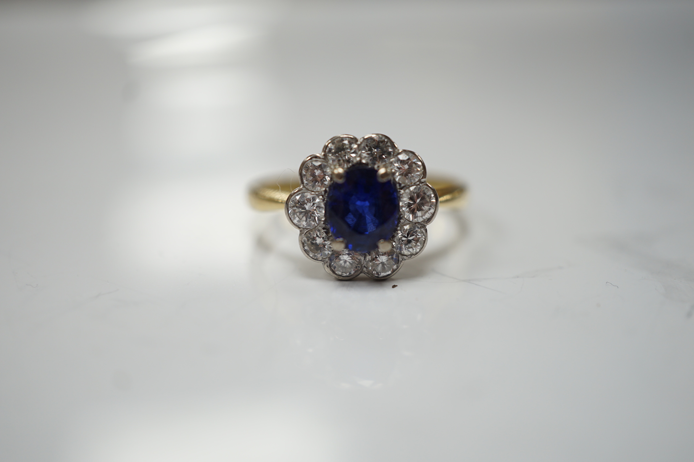 A modern 18ct gold, sapphire and diamond set circular cluster ring, size P/Q, gross weight 3.4 grams.
